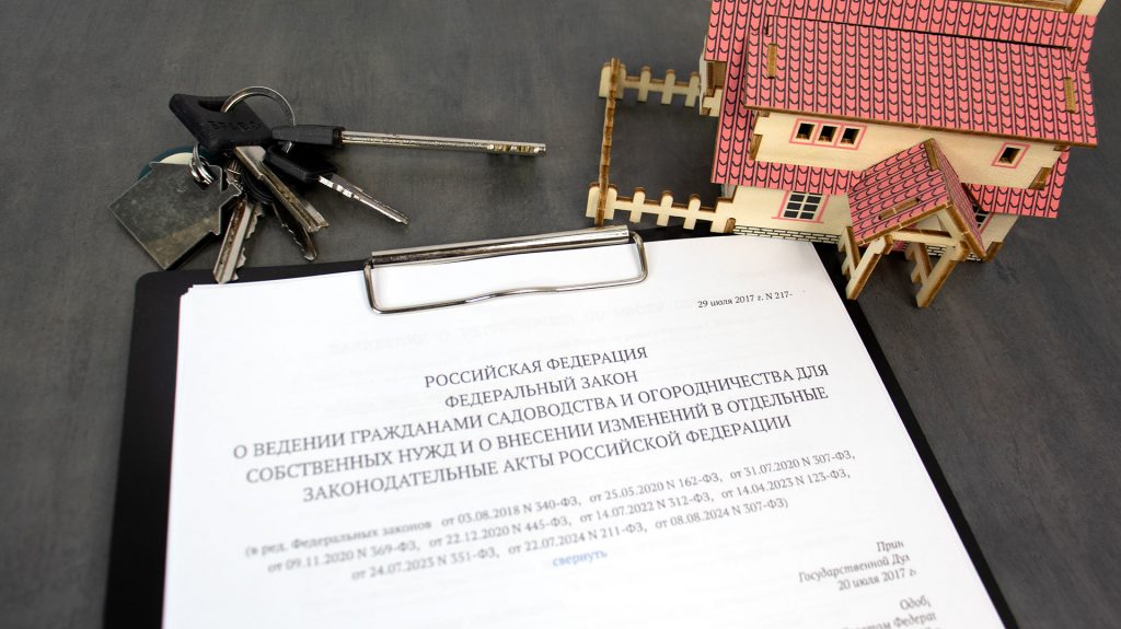 Закон о садоводстве с ключами и макетом дома на фоне