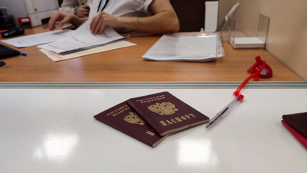 Паспорта и документы на столе в МФЦ при подаче заявления.