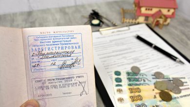 Паспорт с отметкой о регистрации и документы на столе с деньгами