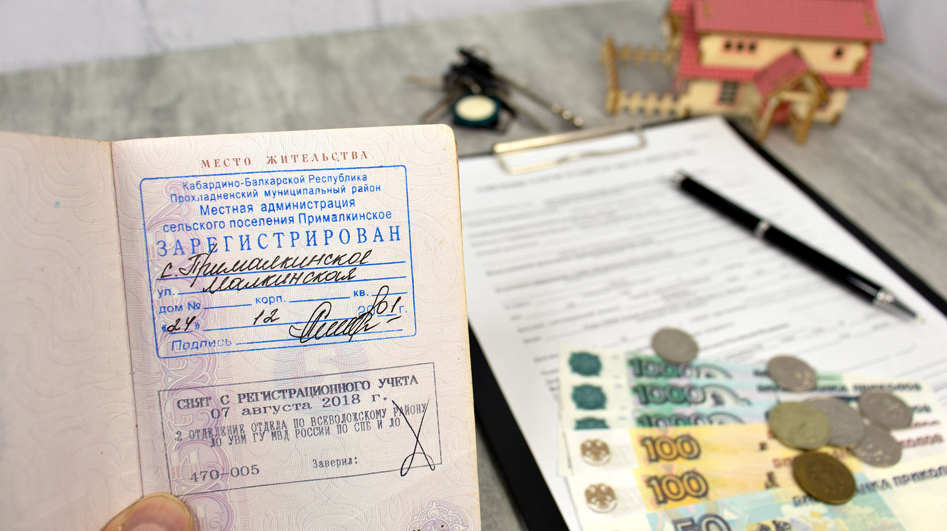 Паспорт с отметкой о регистрации и документы на столе с деньгами