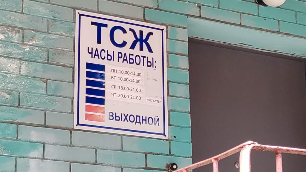 Табличка с графиком работы ТСЖ на стене жилого дома